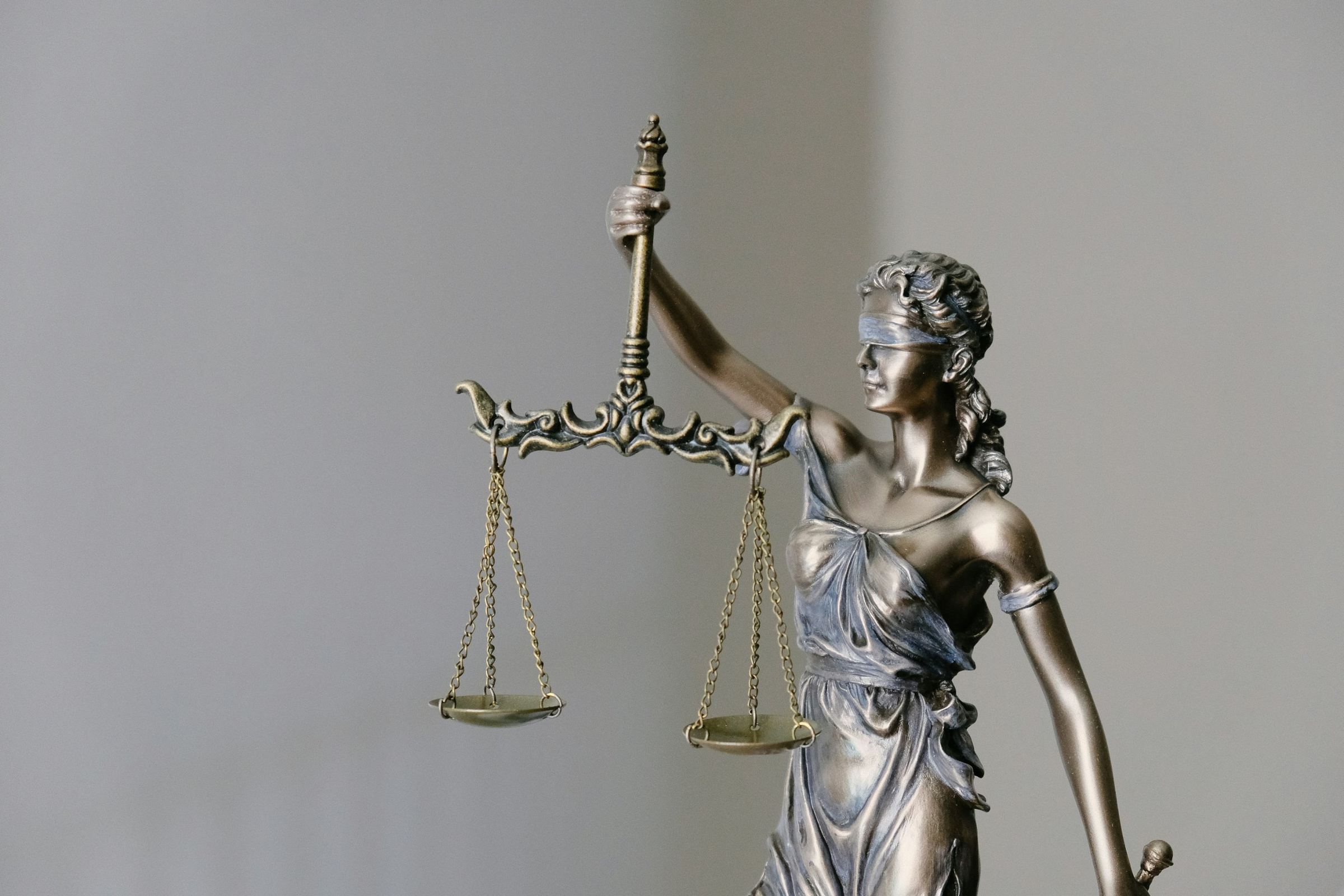 Bronze statue of Justice holding balanced scales